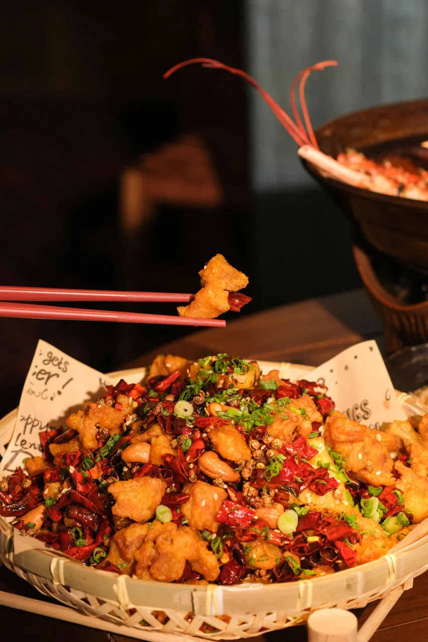 菠萝辣子鸡炸得金黄酥脆，黄梨的微酸与腰豆的绵密恰到好处地穿插其中。（餐馆提供）