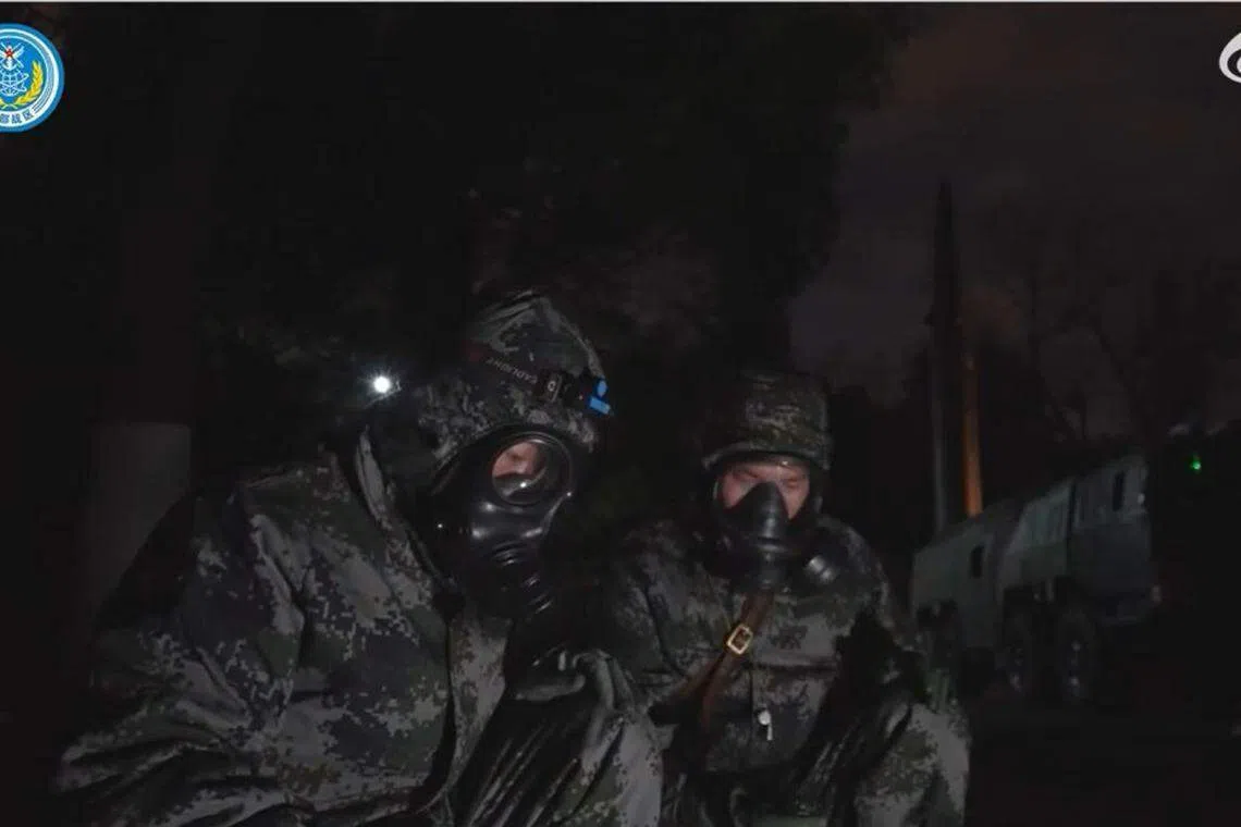 穿防化服的军人在导弹发射前做最后的检查工作。（视频截图）