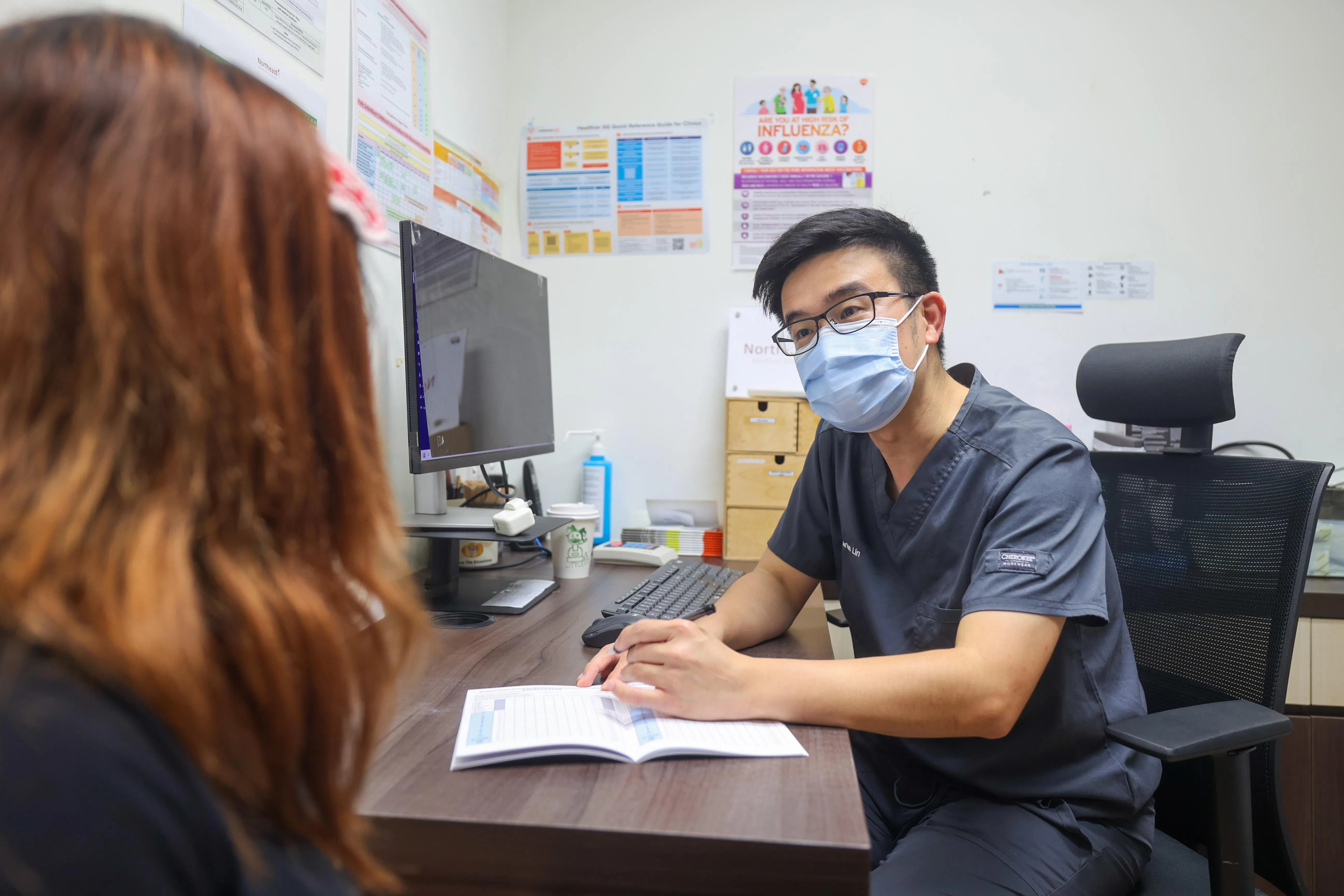 为预防急性呼吸道感染，国人可在出发旅行前接种疫苗，在拥挤的公共场所戴上口罩，注意保持双手清洁。图为东北医疗集团旗下诊所家庭医生林斌在为病患讲解流感的症状和治疗方法。（吴先邦摄）
