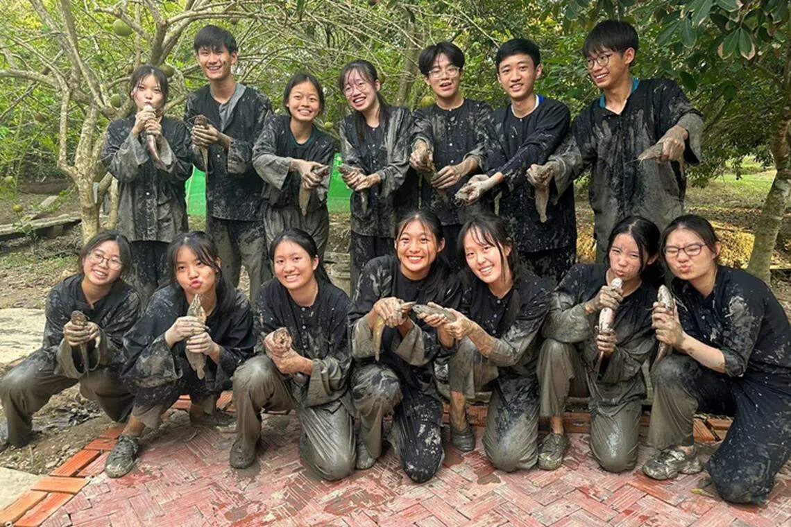 在小溪流捕捞鱼儿，尽管搞得一身泥泞，大家还是非常开心。（华侨中学张嘉玲摄）