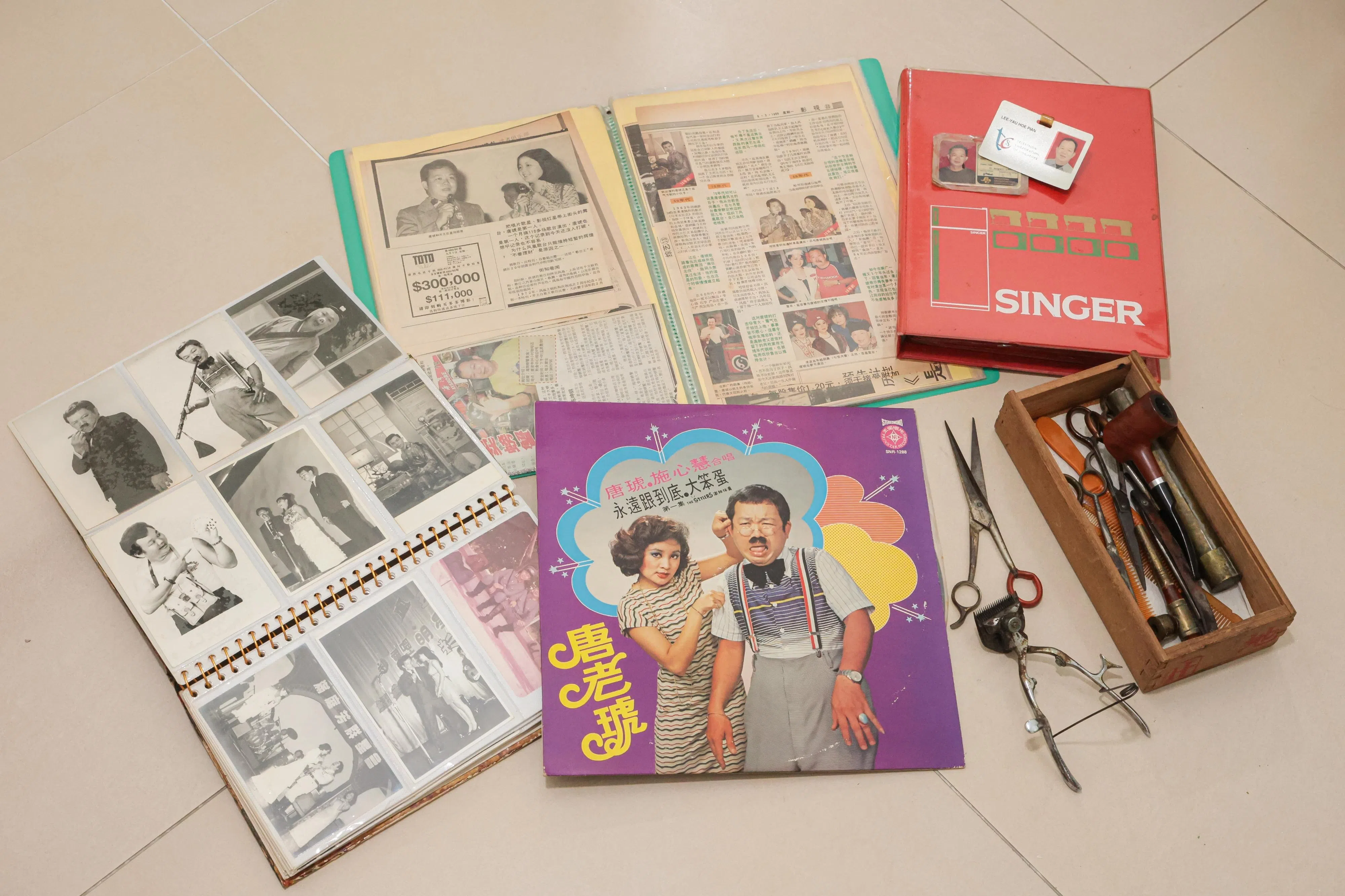 唐琥家人捐出的部分遗物，包括剪刀、剃刀、烟斗、照片、黑胶唱片和剪报等。（李冠卫摄）