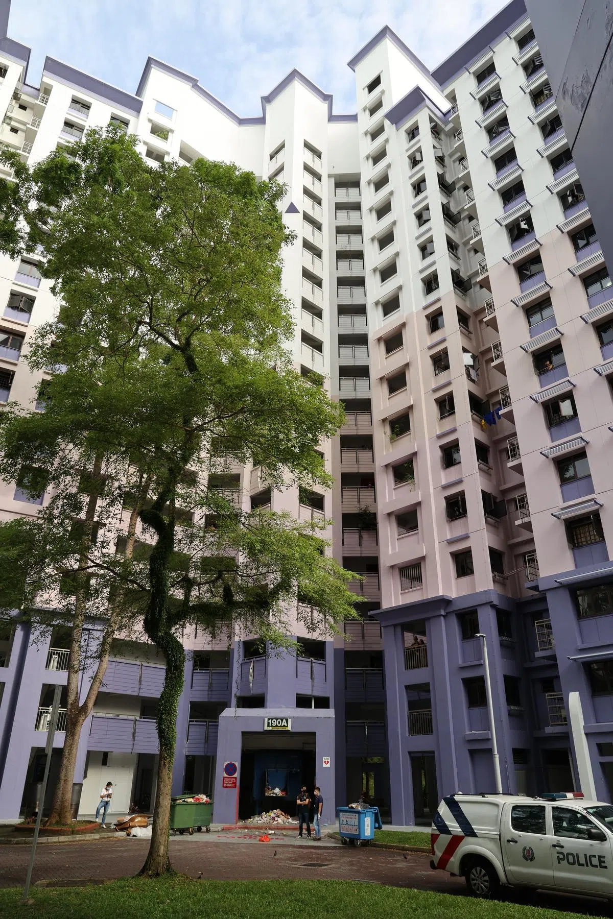 多名警员在案发组屋的垃圾槽搜证，一般相信是在寻找凶器。（刘启成摄）