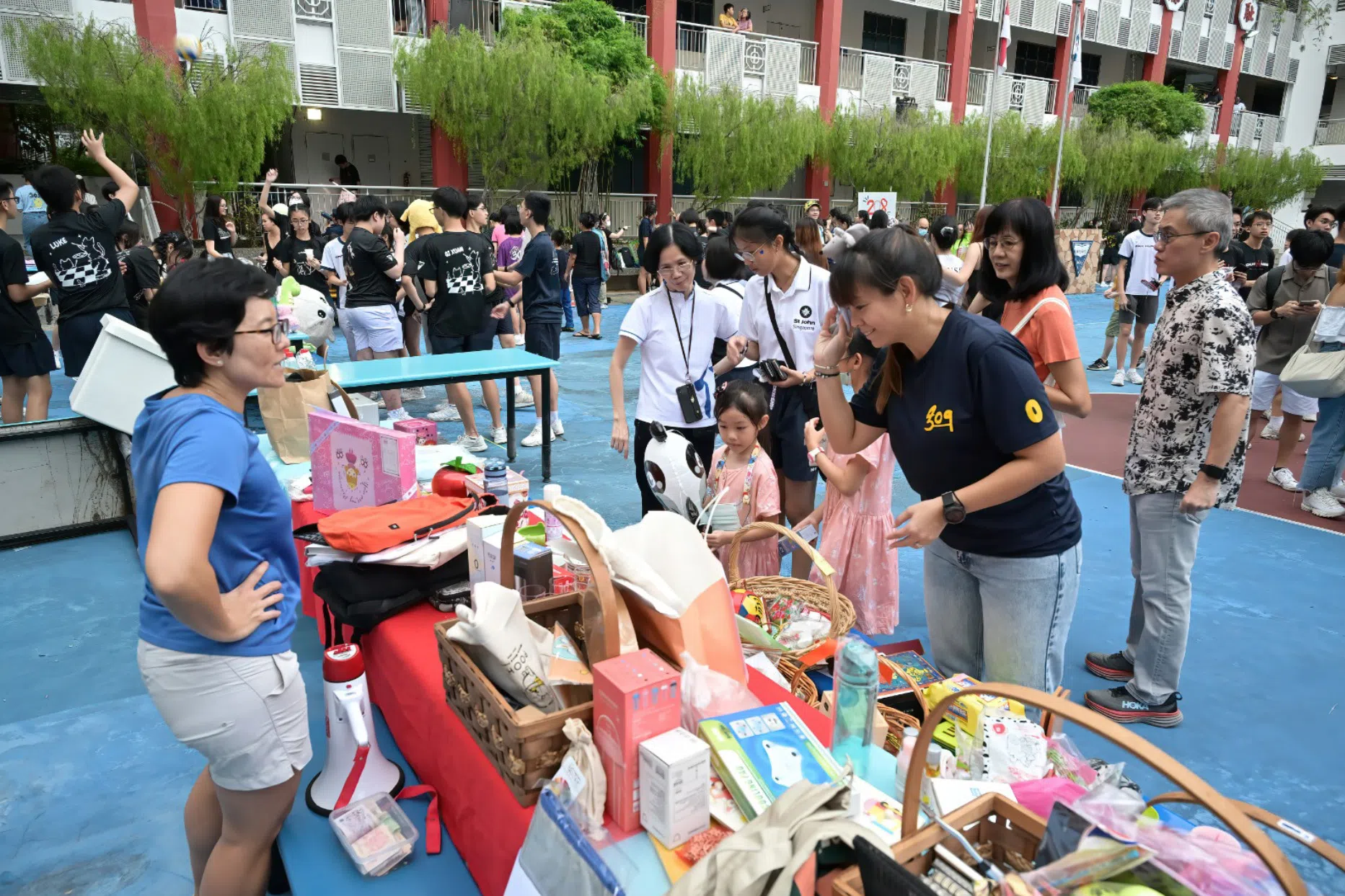 公众支持学生摊位，挑选自己喜欢的商品。（南华中学提供）