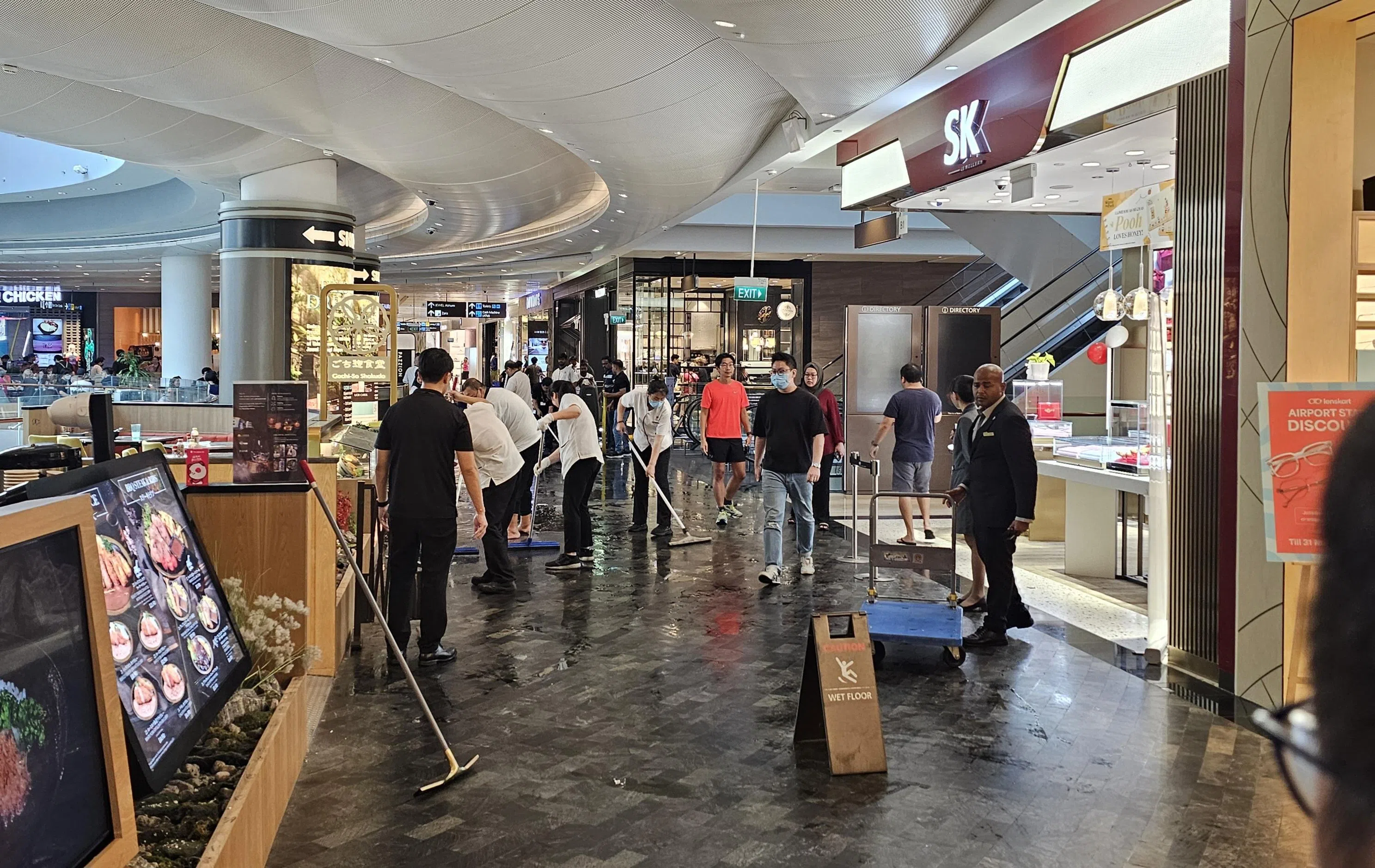 各个店家出动工作人员处理积水。（梁麒麟摄）