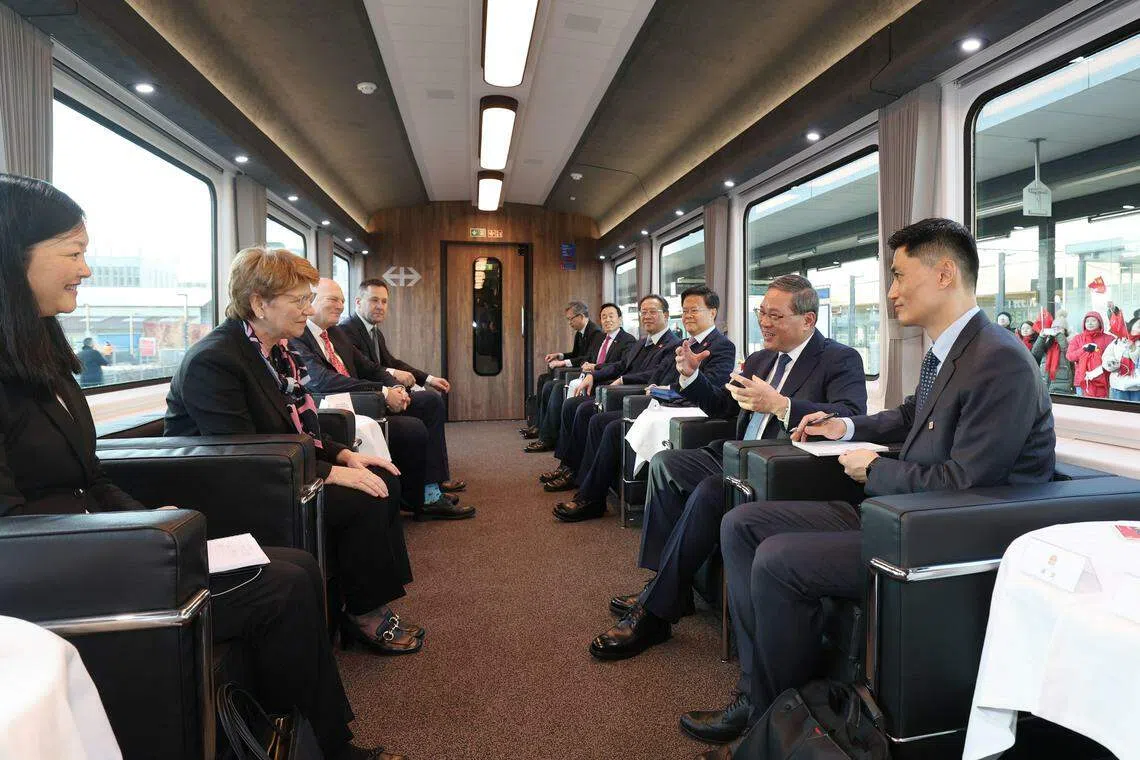 中国国务院总理李强（右二）与瑞士联邦主席阿姆赫德（左二）当地时间1月14日下午共同乘专列自苏黎世前往瑞士首都伯尔尼，一路在轻松友好的氛围中坦诚交流。（新华社）