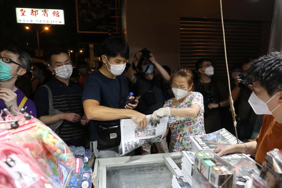 香港市民今天凌晨在旺角的一个报摊购买最后一期的《苹果日报》。（彭博社）