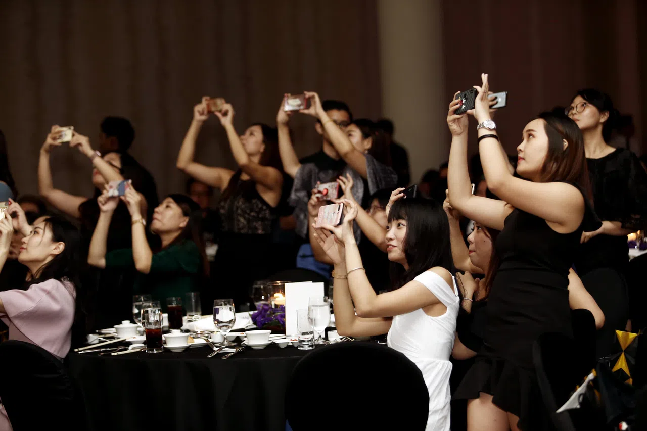 得奖企业的支持者双手高举手机，调好相机设置，捕捉领奖的重要时刻。（档案照片）