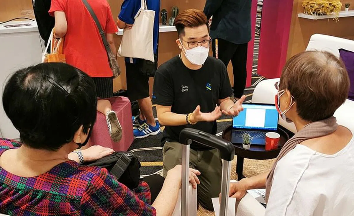 苏宙德（面镜头者）表示，他和团队在两个周末，共教导了超过300名年长者如何用手机与在国外的家人保持联系及处理日常事项。（图/渣打银行新加坡提供）