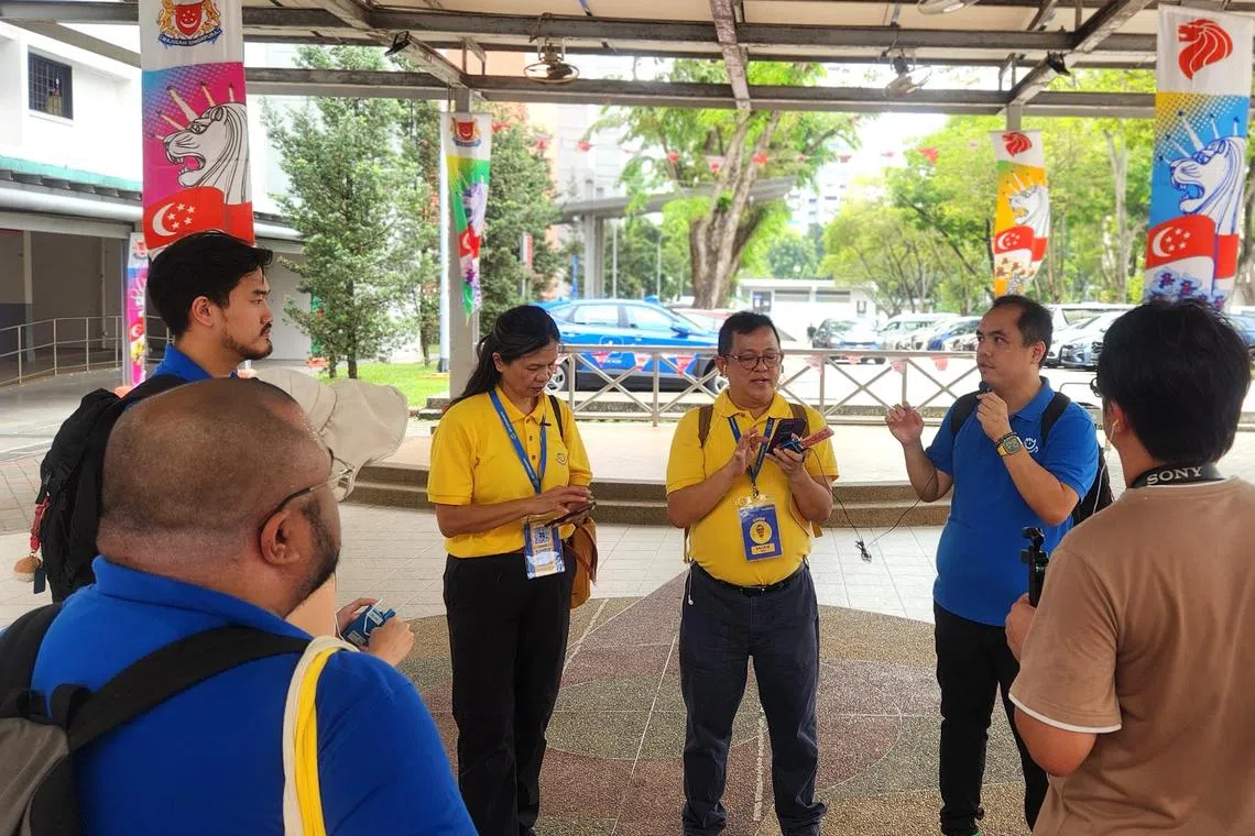 “我的社区” 联合创办人郭俐勇（右二）及两名义务导览员（黄衣者），分享他们对金文泰的美好记忆。（陈爱薇摄）