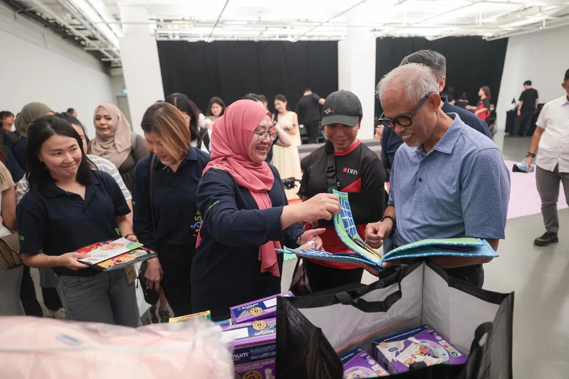 所有参与星展银行基金会和幼儿培育辅助计划（KidSTART）孕妇和婴儿营养项目的准妈妈，可获得一个物品多元的产前礼包。社会及家庭发展部长马善高（右一）向工作人员了解礼包内的育儿用品。左二起为幼儿培育辅助计划首席执行官陈主恩（被遮挡）及星展银行基金会董事、星展银行集团推广策略及传讯处负责人魏洪英。（李冠卫摄）