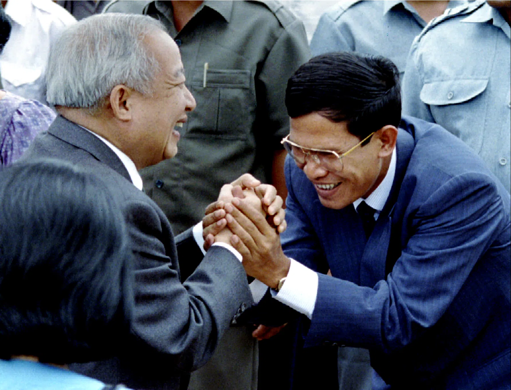 1993年5月22日，柬埔寨内战后的首届全国大选前夕，西哈诺（左）抵达金边，受到时任政府领导人洪森迎接。（路透社）