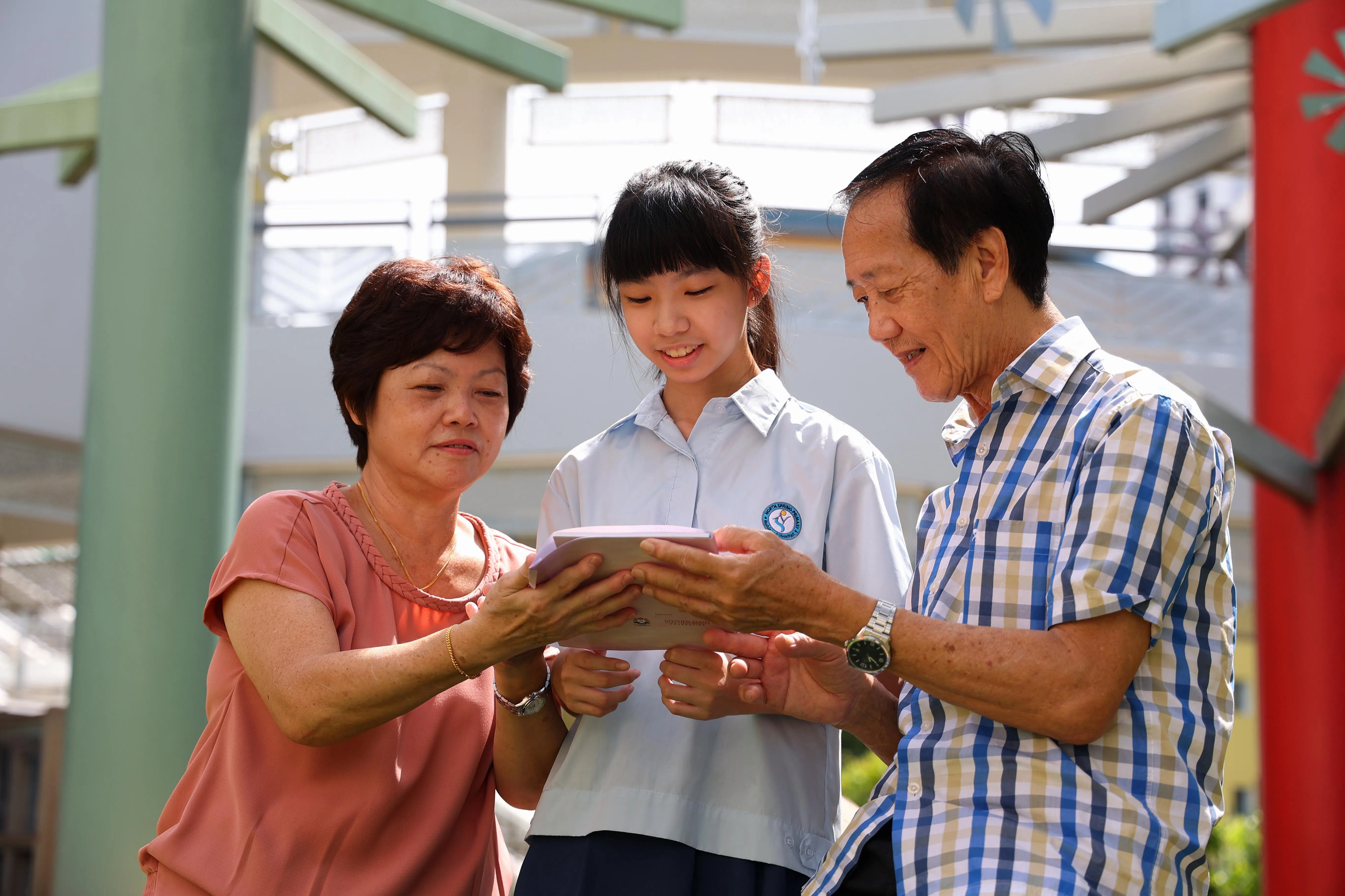 范雯茵（中）与外婆温财贵和外公陈成福分享自己所写的文章内容。她在记录外婆童年经历的过程中，意识到自己这一代的生活幸福多了，应珍惜所拥有的。（林明顺摄）