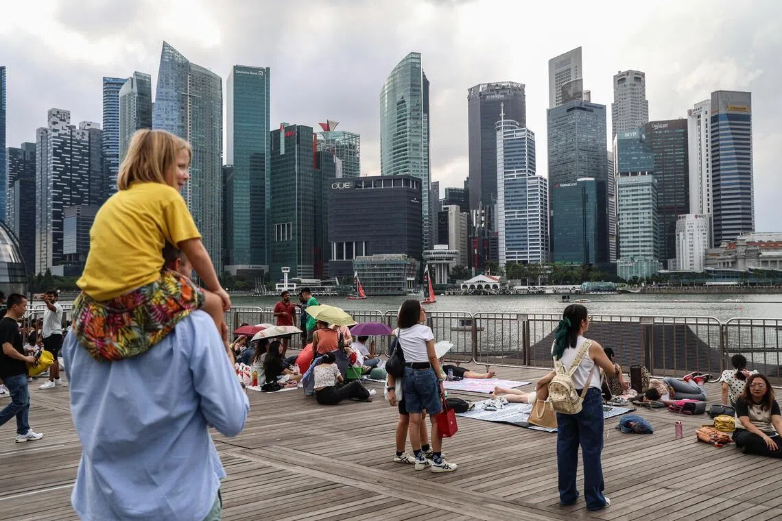 不少公众为抢占观赏跨年烟花的好位置，特地提前到滨海湾一带等候。（关俊威摄）