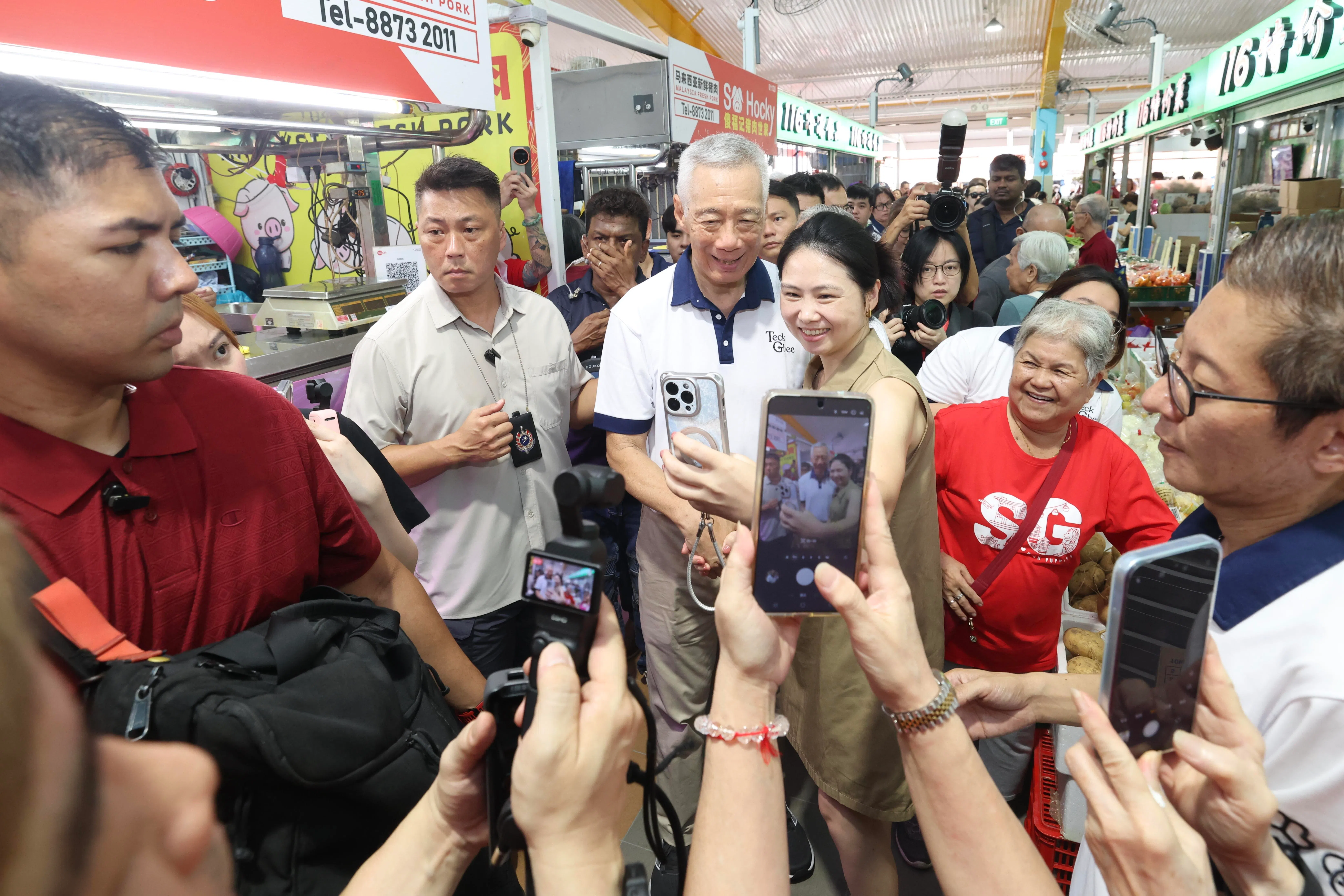 国务资政李显龙（左三）星期天（8月9日）在整修后重开的宏茂桥巴刹与小贩中心与居民合影。（郑一鸣摄）
