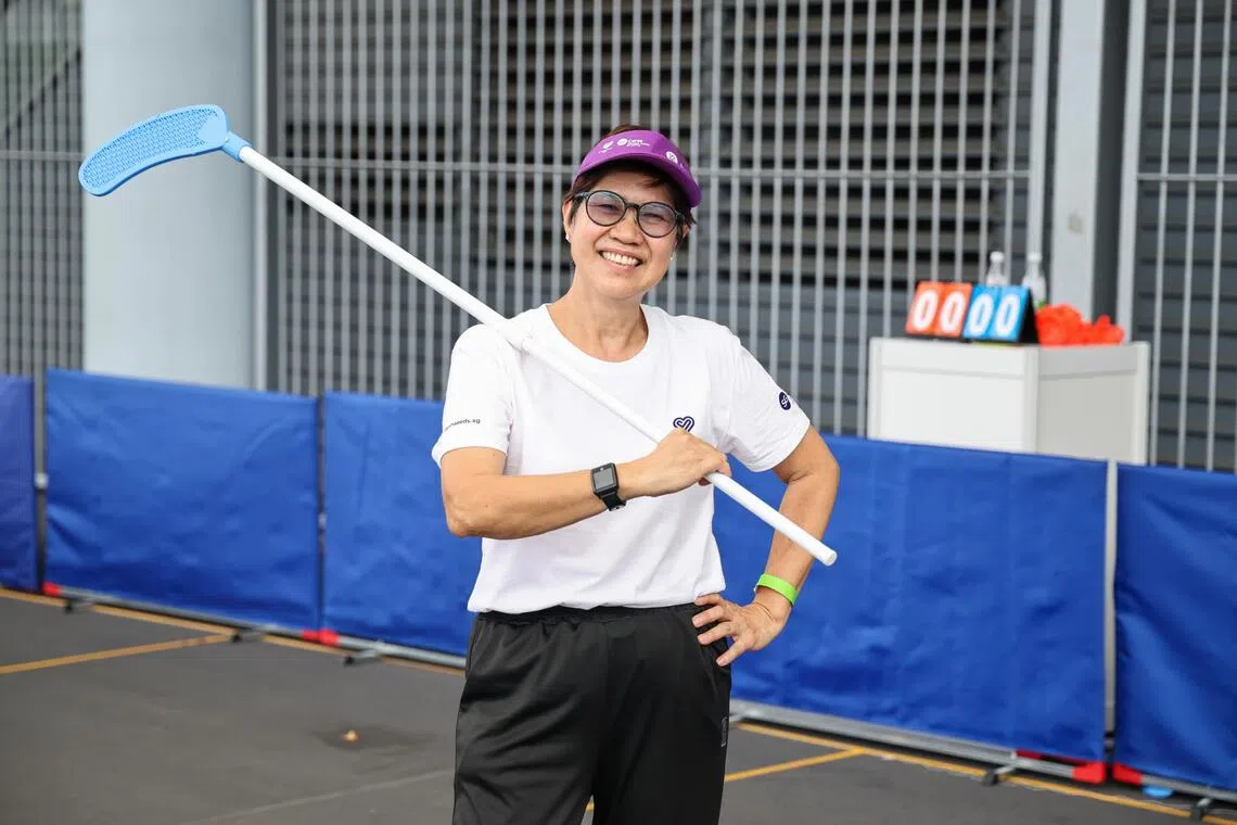 福善活跃乐龄中心的卢燕琼（67岁，数据录入员）和四名队员，参与设计了方格曲棍球的玩法和球杆。（陈渊庄摄）