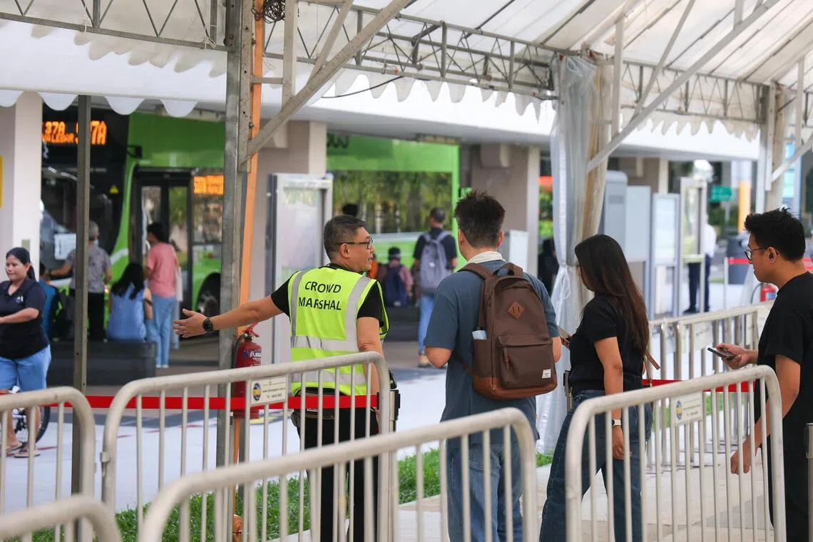 好些乘客不知道环线已恢复正常运作，星期五还是到实龙岗站外的接驳巴士等候区等车。工作人员不断提醒，接驳巴士只运行到下星期一（13日）。（张俊杰摄）