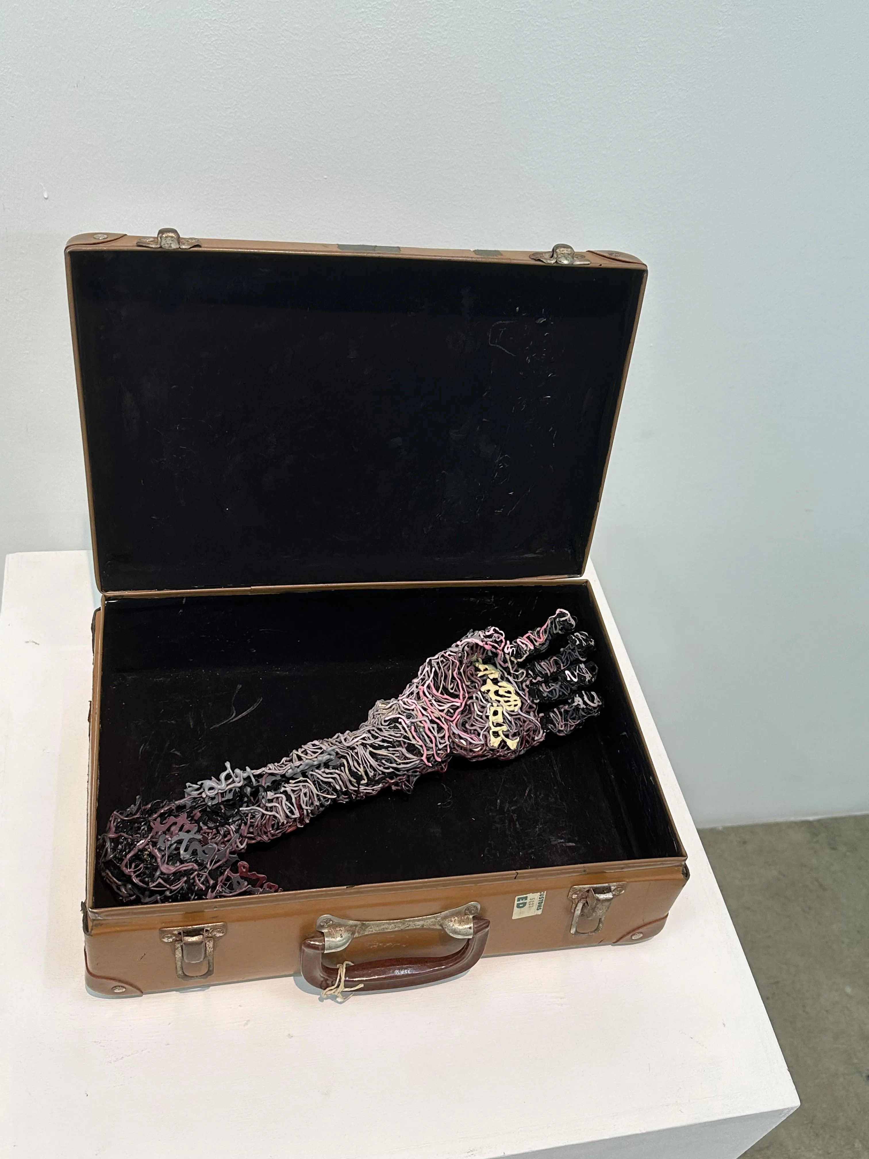 “My Left Hand Operates at 25% Capacity”，一只由线条构成的左手臂平放在行李箱中，掌心刻上马福民在英语世界难以使用的中文全名。（孙靖斐摄）