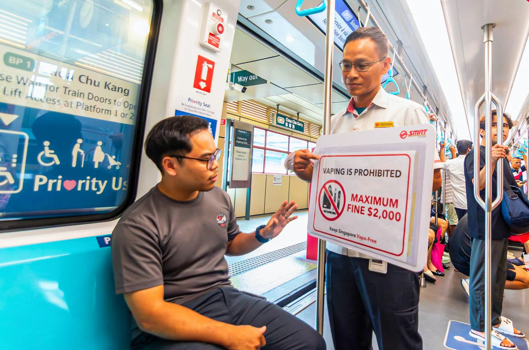 SMRT站务人员会在地铁月台和车厢内举牌提醒乘客，公共交通全面禁止吸食电子烟。（取自SMRT脸书）