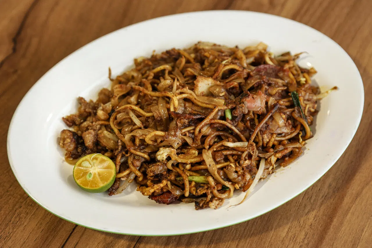 炒粿条料足味美，有腊肠、鸡蛋、鱼饼、血蛤等食材，猪油渣锦上添花。（刘欣怡摄）