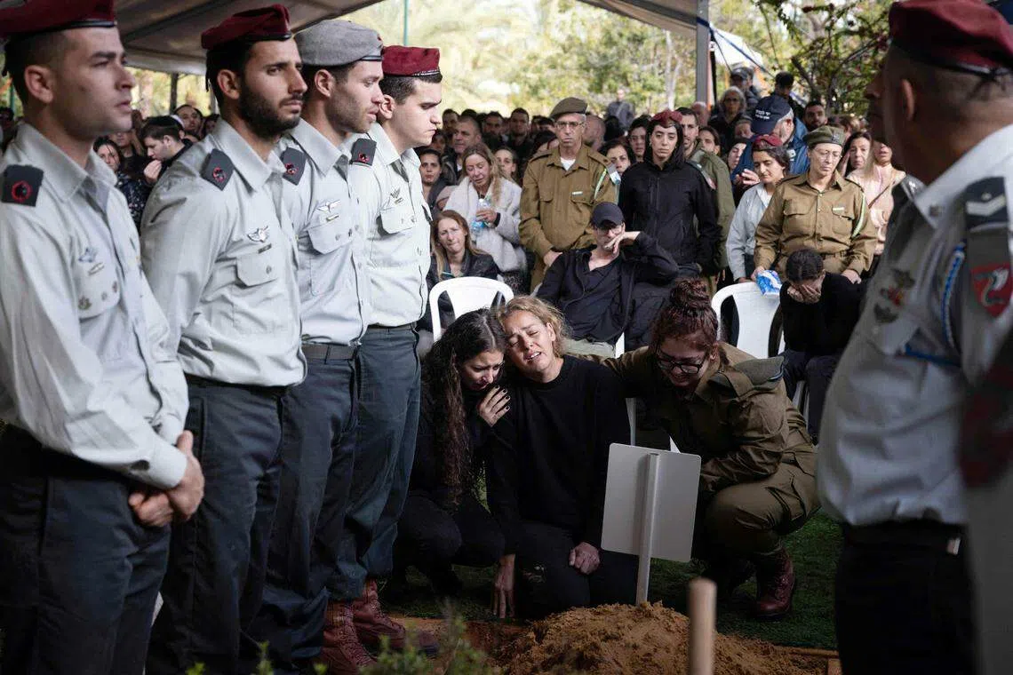 以色列政府说，战争已导致以方221名士兵阵亡。星期二（1月23日）在特拉维夫军人公墓举行的葬礼上，一名阵亡士兵的母亲哀悼死去的孩子。（法新社）