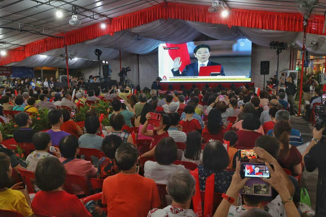 马西岭—油池居民一同观赏黄循财总理的就职仪式，活动现场几乎座无虚席。（唐家鸿摄）