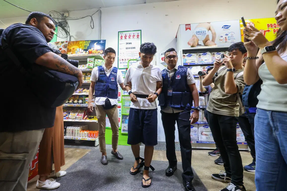 星期四早上约10时45分，20岁男子诺拉伊迪尔萨希克（Muhammad Noraidilsahiq Bin Muhammad Norasif）被带回盛港西道第455座组屋的昇菘超市。（陈斌勤摄）