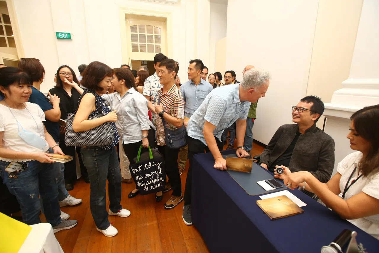 发布会上座无虚席，活动结束后，杨伟仁（右二）与现场观众交流，朋友也代为以盖章“签”书。（特约陈福洲摄）