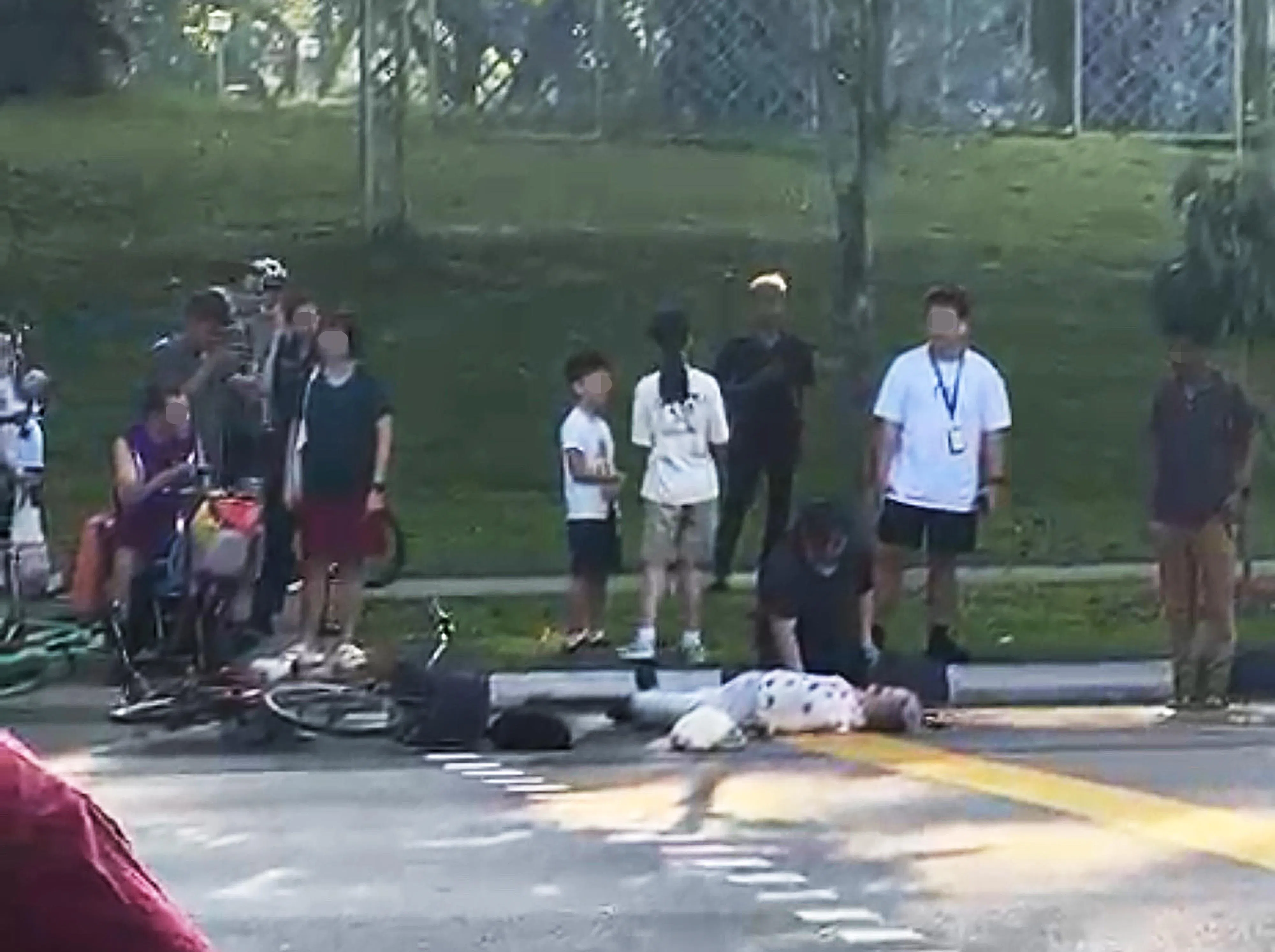 视频显示，一名身穿白色衣服，头发灰白的妇女倒在马路上，头部受伤，鼻孔出血，一旁也有翻覆的脚踏车。（受访者提供）