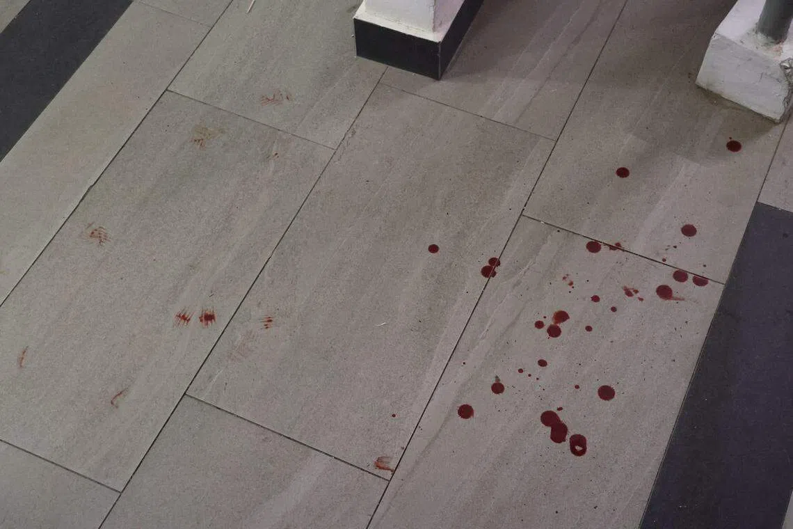 《联合早报》记者到达玛格烈通道第31座组屋时，发现地面层血迹斑斑，警方正在现场调查。（邝启聪摄）