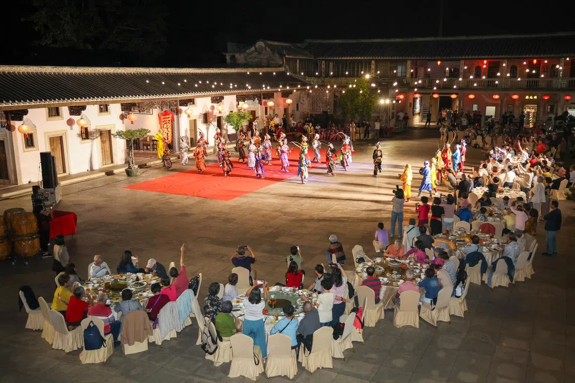 120位团员在大宅庭院中品美食看表演。（林明顺摄）