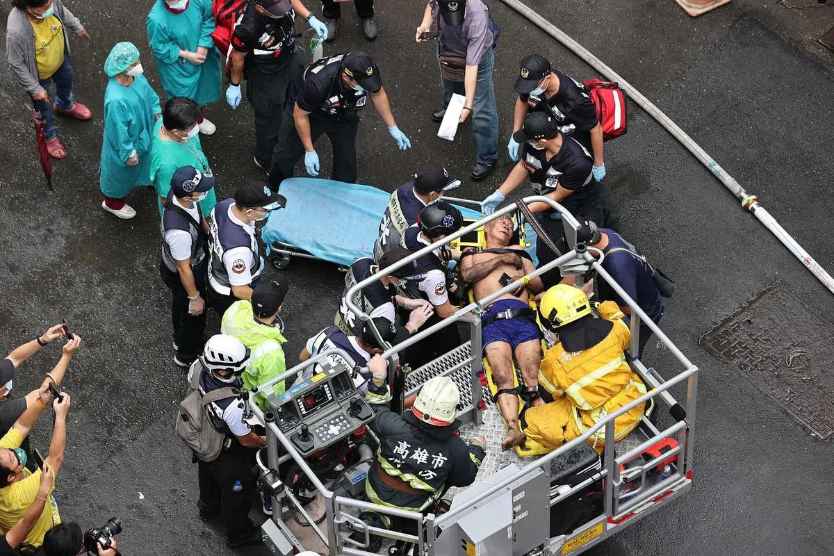 高雄市消防局共出动75车159人赶往失火的“城中城”大楼抢救。消防人员进入大楼逐层搜查，并用云梯车救出受困屋内的民众。（中通社）