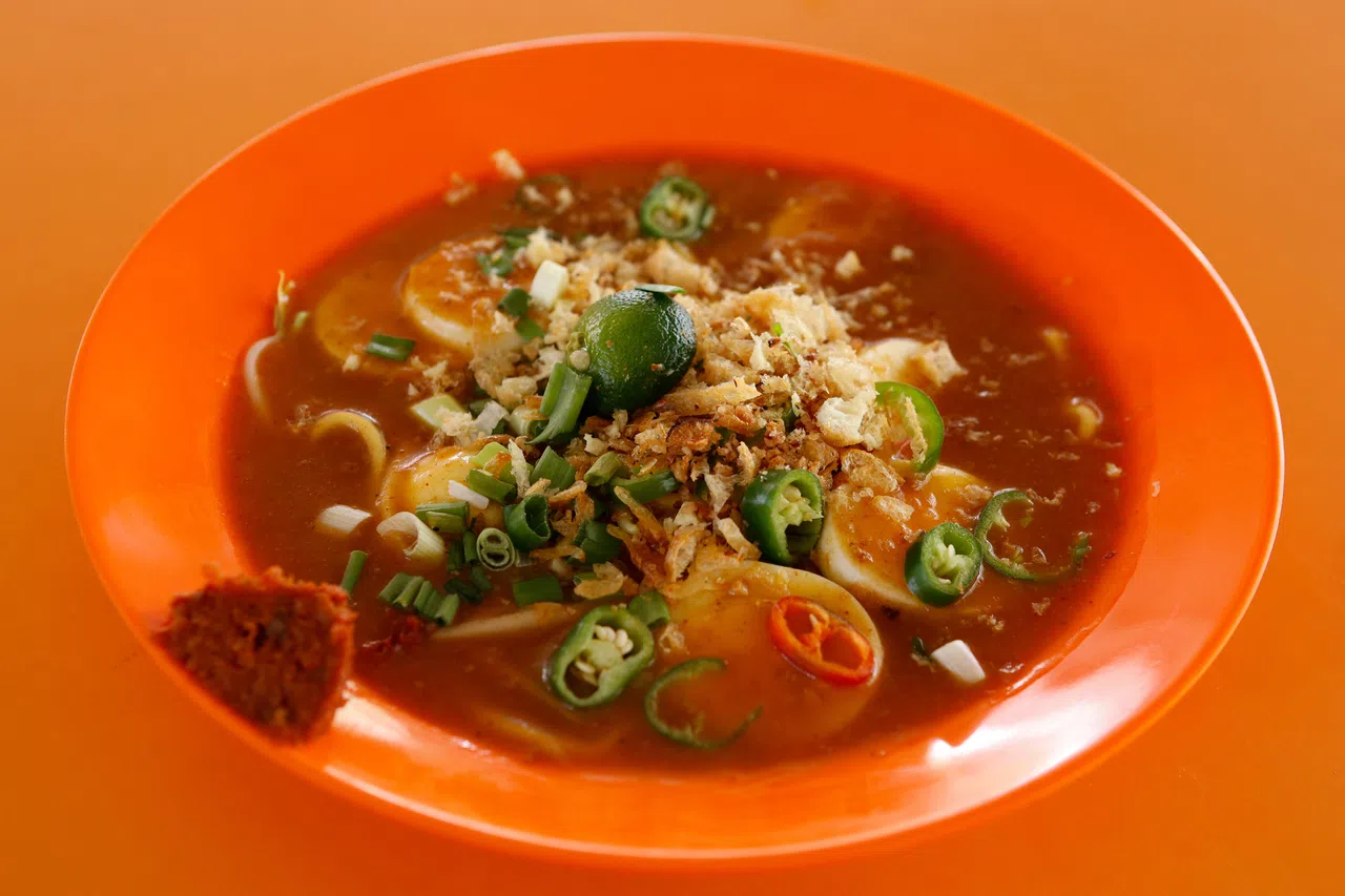 享用马来卤面时，挤一点酸柑汁提鲜，再加上微辣的自制辣椒酱，口感丰富。（特约李姿仪摄）