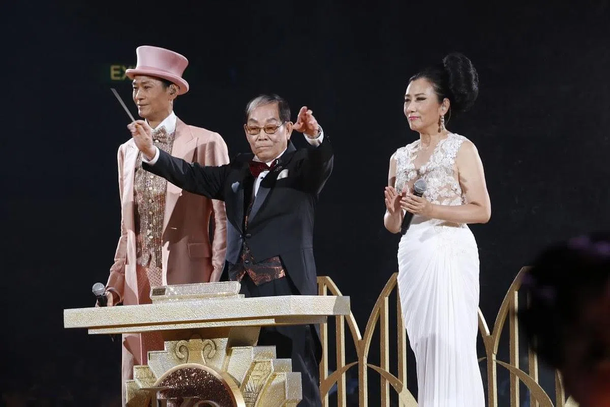 顾嘉辉在荣休演唱会上当指挥，他身旁为郑少秋及汪明荃。（互联网）