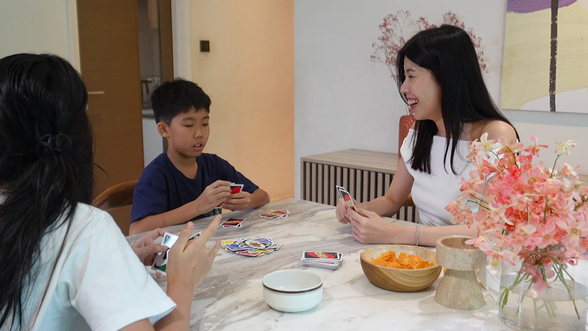 赵文雁（右）会抽出时间与儿女玩桌游促进感情，不让他们过度沉浸在电子世界里。（视频截图）