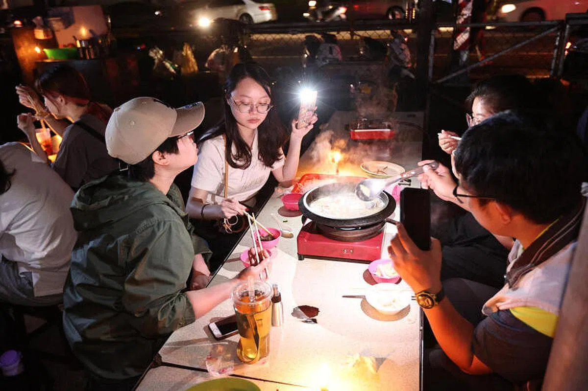 高雄瑞丰夜市昨晚依旧未恢复供电，民众用手机或蜡烛照明，吃“烛光晚餐”。（香港中通社）