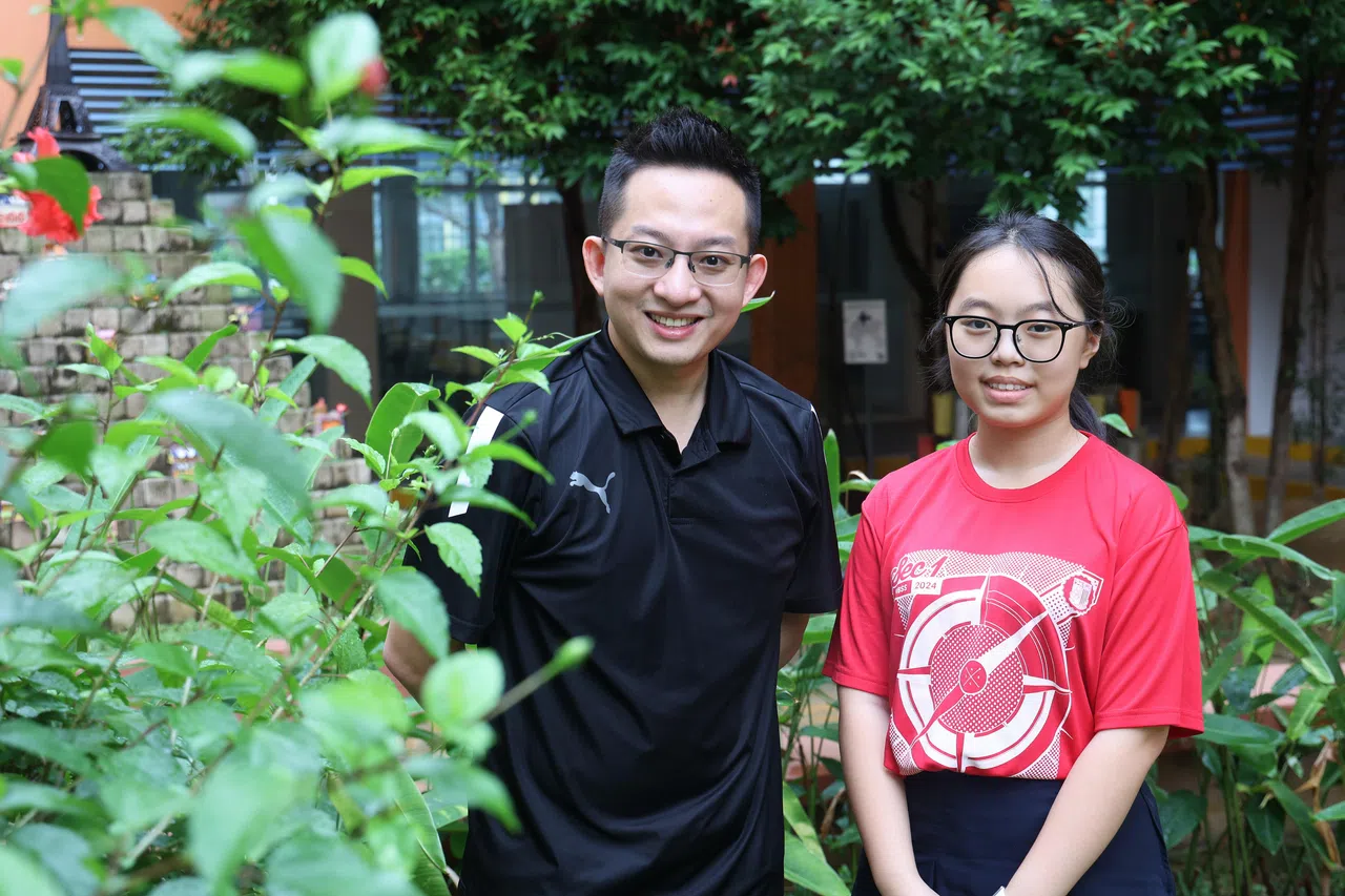 军港中学学生谢佳灵（右）觉得大合唱十分温馨，华文教师颜梓恩（左）把新谣融入教学中。（唐家鸿摄）