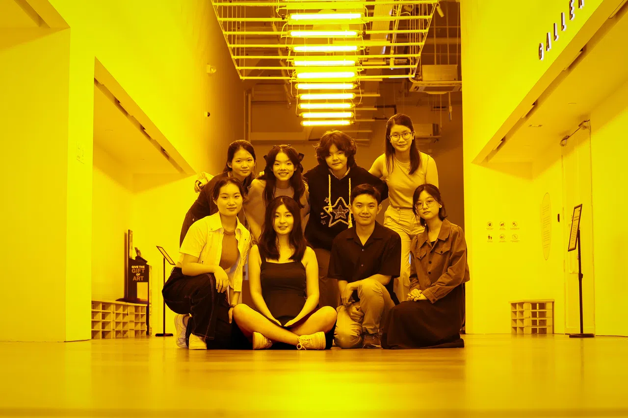 第九代字食族成员2024年聚集新加坡美术馆，八人首次合影留念。拍摄现场是冰岛－丹麦艺术家Olafur Eliasson的装置艺术作品《黄色走廊》（Yellow corridor）。 （龙国雄​摄）