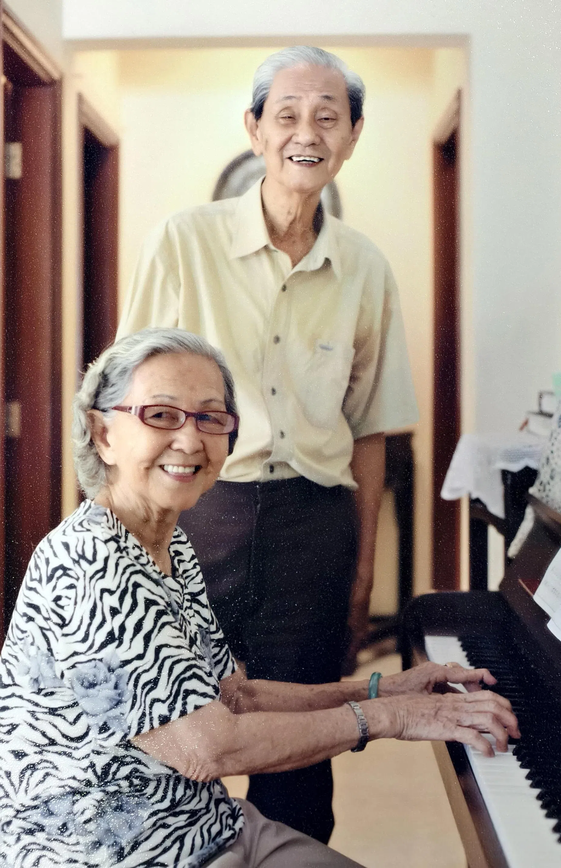 已故书画家林子平与妻子苏秀丽感情恩爱，鹣鲽情深。约20年前苏秀丽在住家弹钢琴，林子平与她合照。（家属提供）