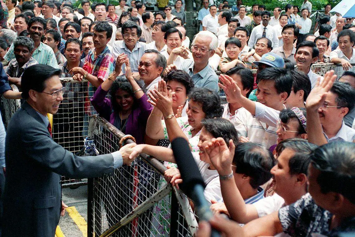 王鼎昌（左）是我国首任民选总统，当选后也成为了保管国家储备金的第二把钥匙。图为王鼎昌1993年参选时，与支持者握手。（海峡时报）