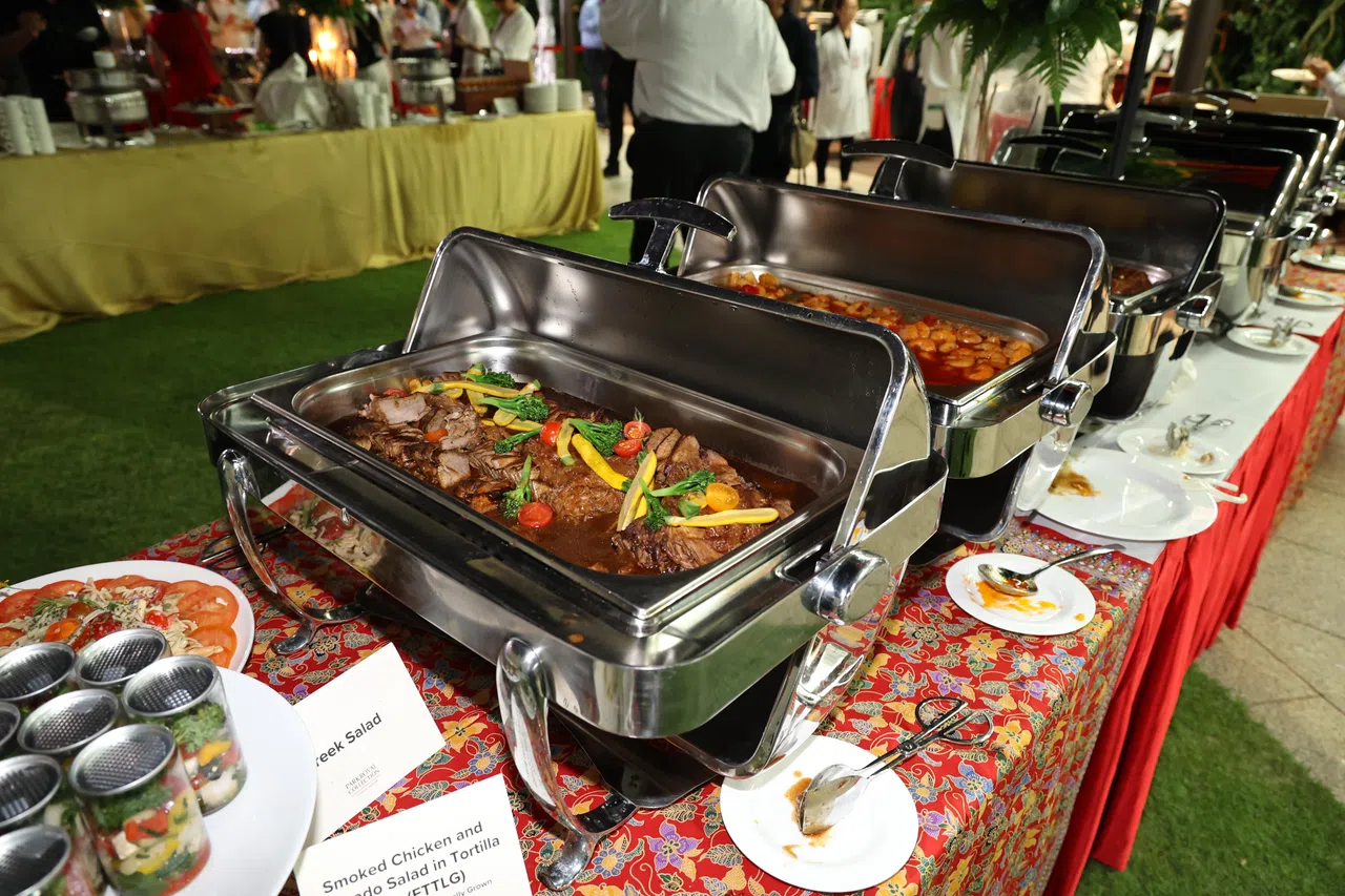 就职典礼上招待宾客的自助餐中，烤鸭沙拉、马来糕、蝶豆花椰浆饭等11道菜肴都融入本地生产的食材。（何家俊摄）