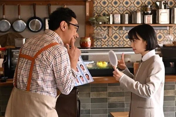 芦田爱菜饰演的南田南（右）第一天上班前，在角田晃广饰演的父亲面前，拿着镜子练习表情。（互联网）