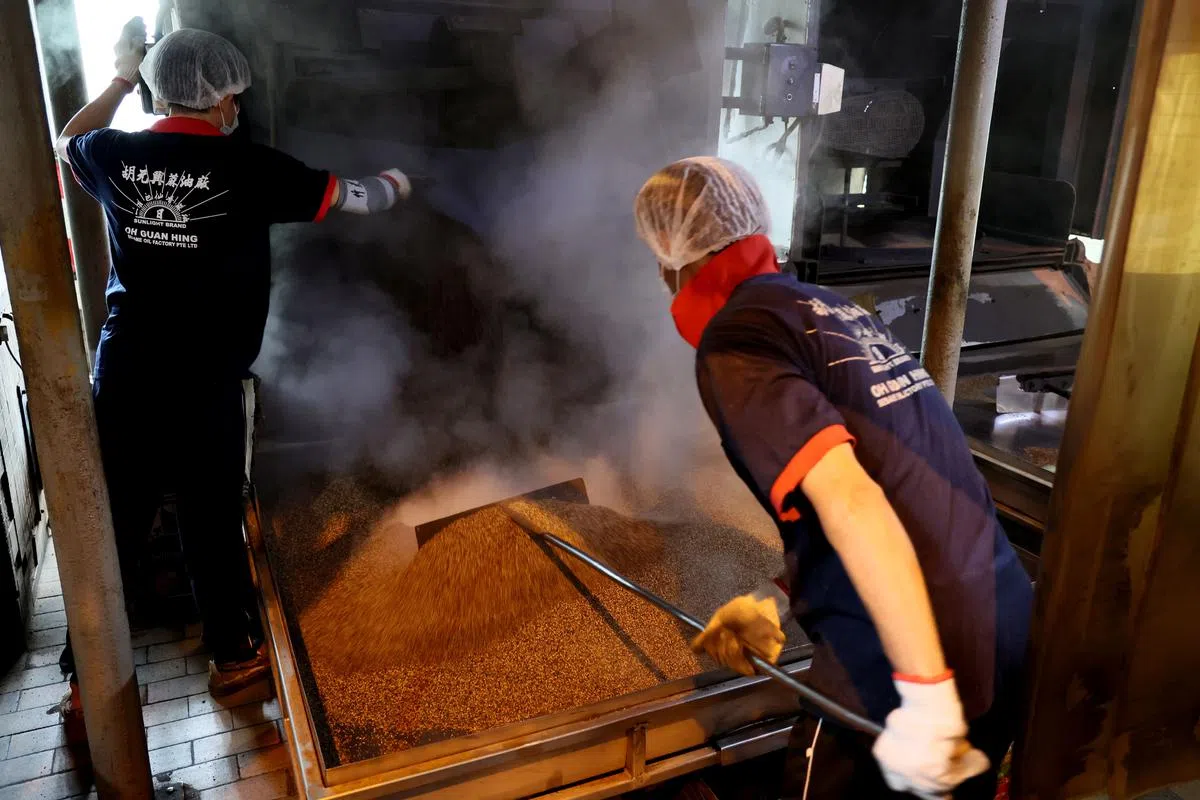 【炒麻】芝麻炒香后倒出，推开散热。（龙国雄摄）