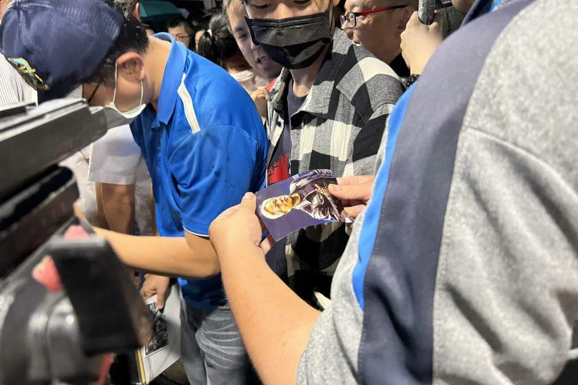 英伟达执行长黄仁勋5月下旬起访问台湾两星期， 所到之处充满热情粉丝索要签名、合照。 图为台湾代工大厂广达集团创办人林百里6月5日晚间在台北宴请黄仁勋时，民众拿着黄仁勋照片，等待黄仁勋签名。 （缪宗翰摄）