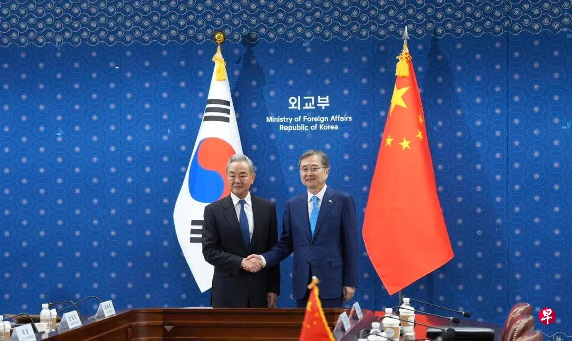 中共政治局委员、中国外交部长王毅当地时间星期三（8月19日）在首尔同韩国外长赵显举行会谈。图为王毅（左）和赵显（右）握手合影。 （中新社）