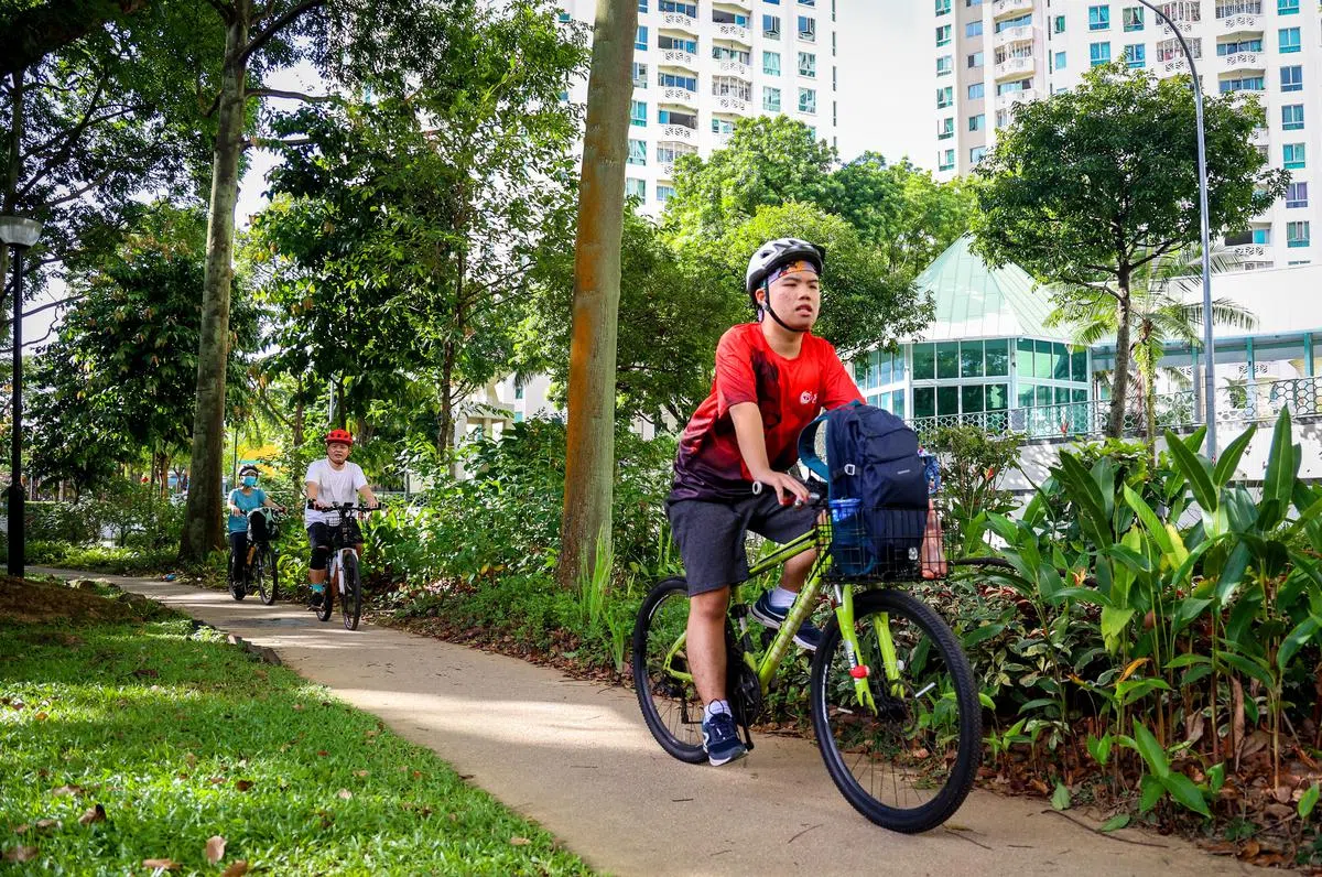 骑行对患有自闭症的乐乐来说，是对自我学习能力的一个挑战。他学习如何在骑行时听爸妈口诉的指令，甚至还“领头”骑行，自我挑战。（叶振忠摄）