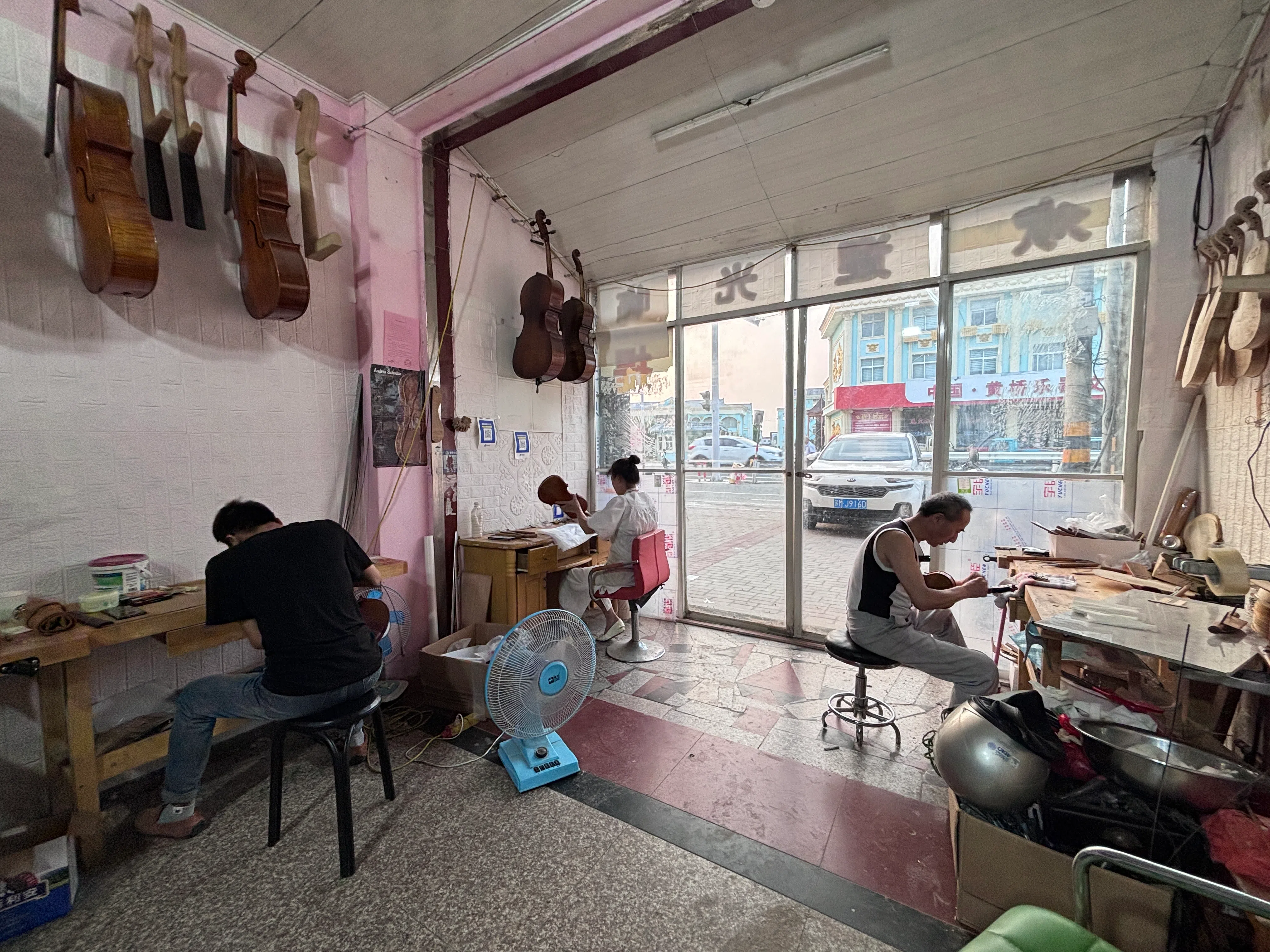 江苏省黄桥镇少宝小提琴工作室内，吕家三口人正在制作小提琴。（黎康摄）