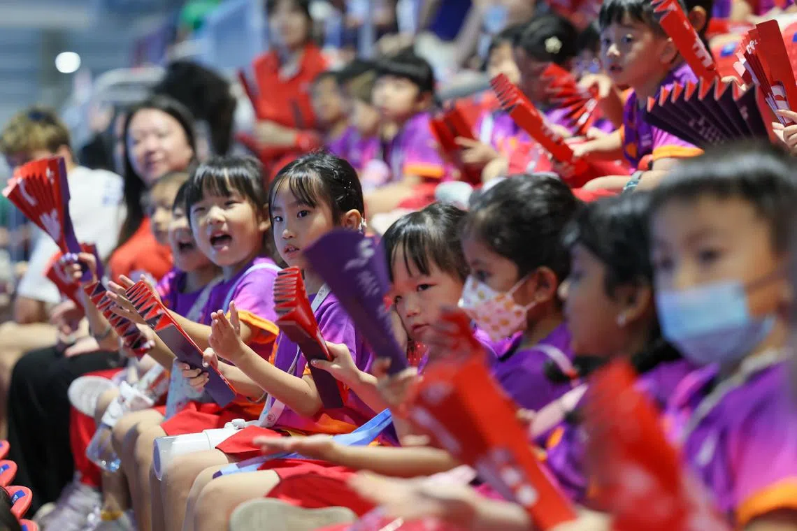 小尼拉会一起挥动手中的加油扇，为游泳运动员助威。（张俊杰摄）