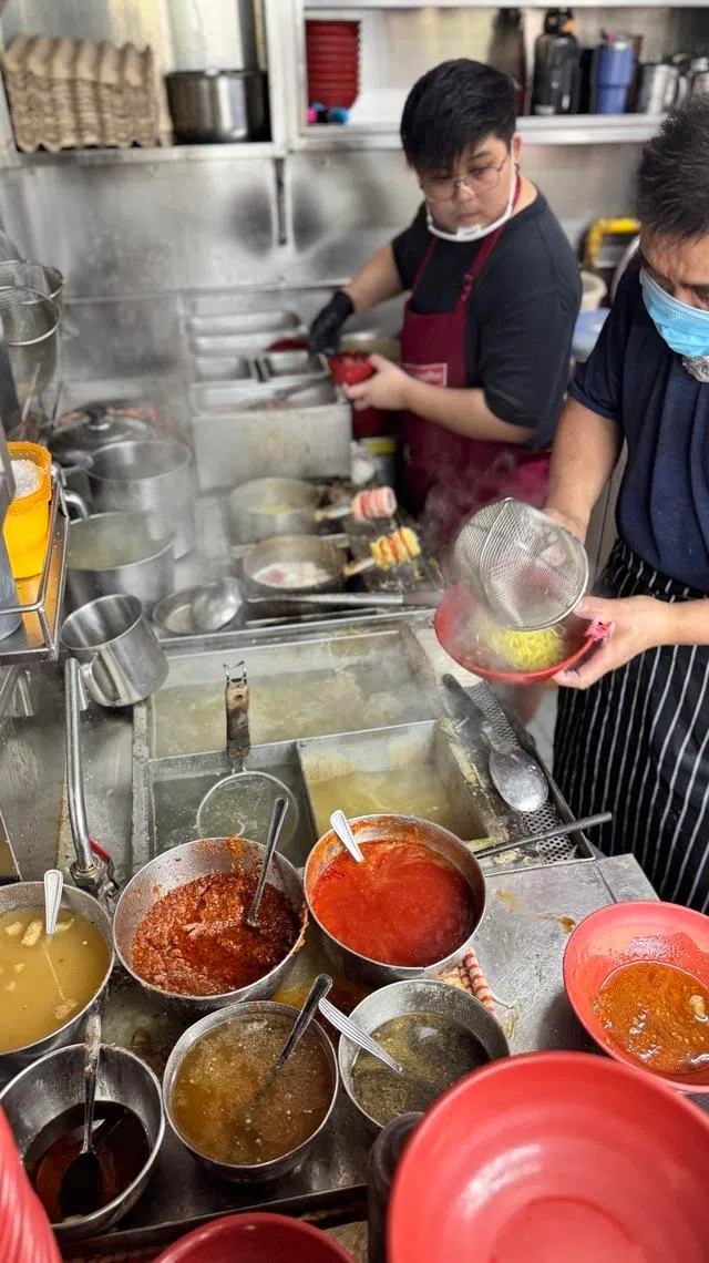 罗卉淇在父亲身旁认真学艺。（翁铭芯摄）