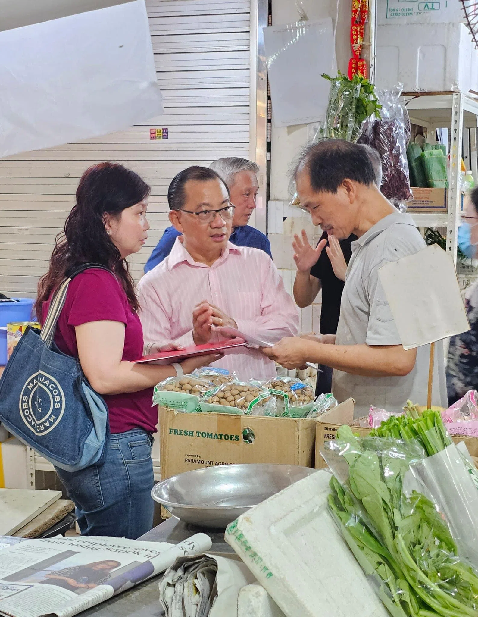 谢健平（中）与基层领袖连同建屋局人员，2月底向湿巴刹摊主说明新计划。（取自谢健平脸书）