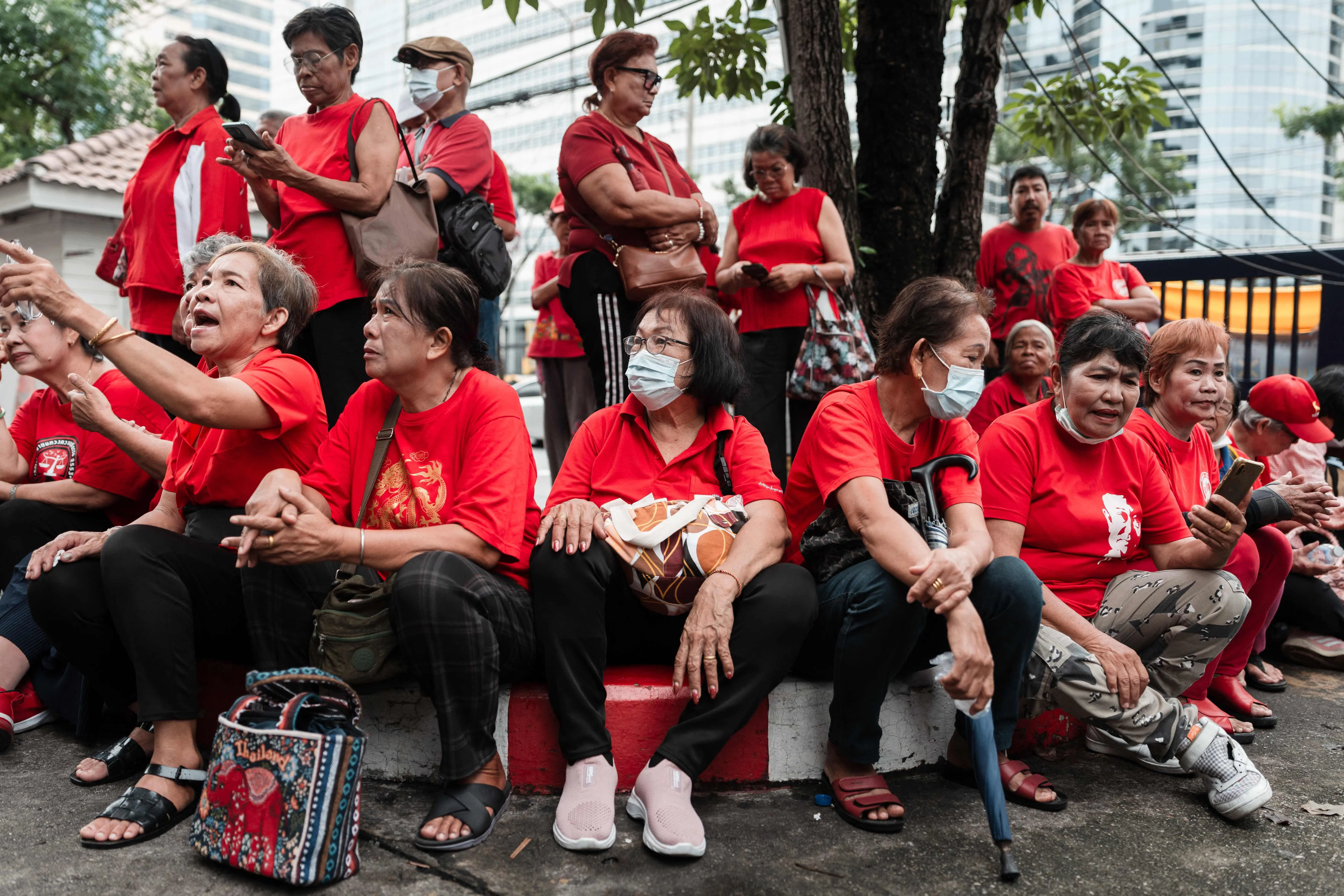 7月16日，约50名身穿红色上衣的达信支持者到曼谷刑事法庭外为达信打气。（法新社）